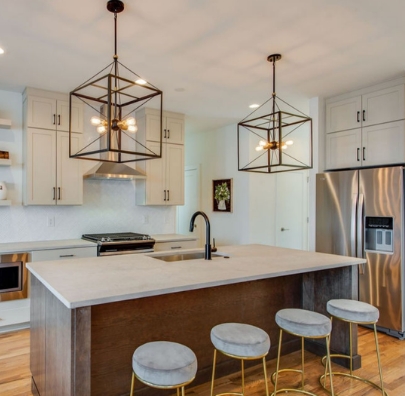 Bright kitchen island with light countertop and pendant lighting