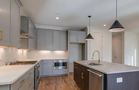 Finished kitchen with gray cabinetry and island countertop