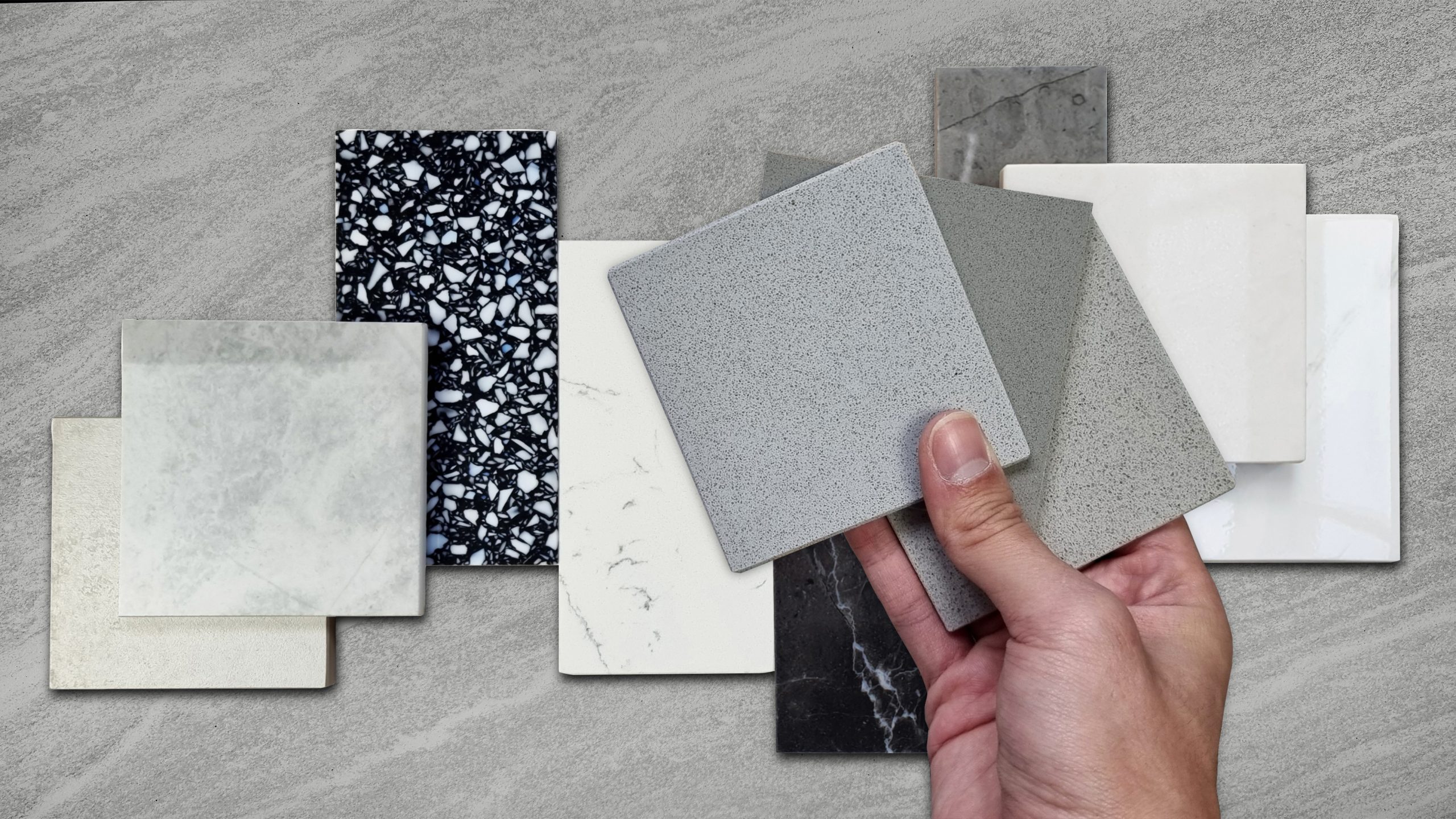 Three countertop slab samples - quartz, granite, and quartzite - laid side by side on a selection table for choosing a Nashville kitchen countertop material.