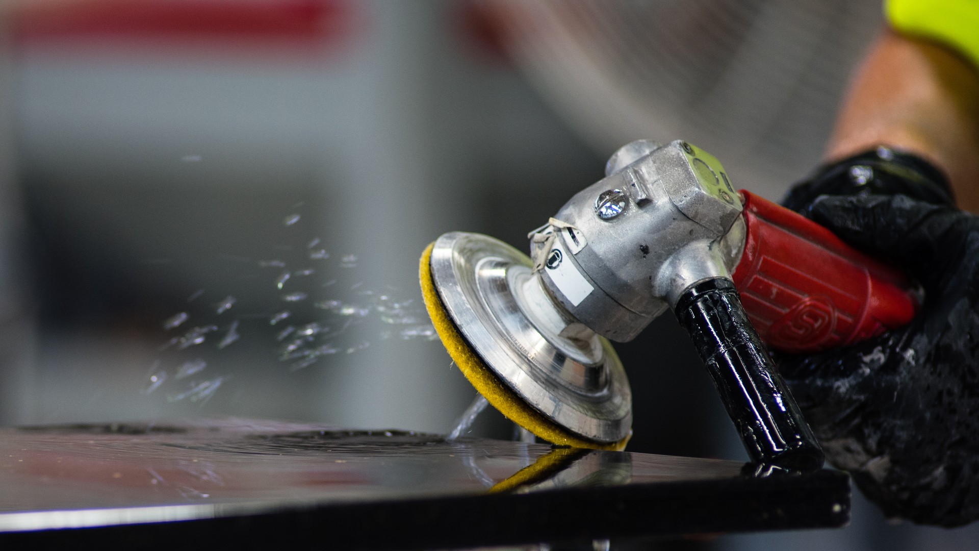 Close-up of a fabricator polishing the edge of a stone kitchen countertop