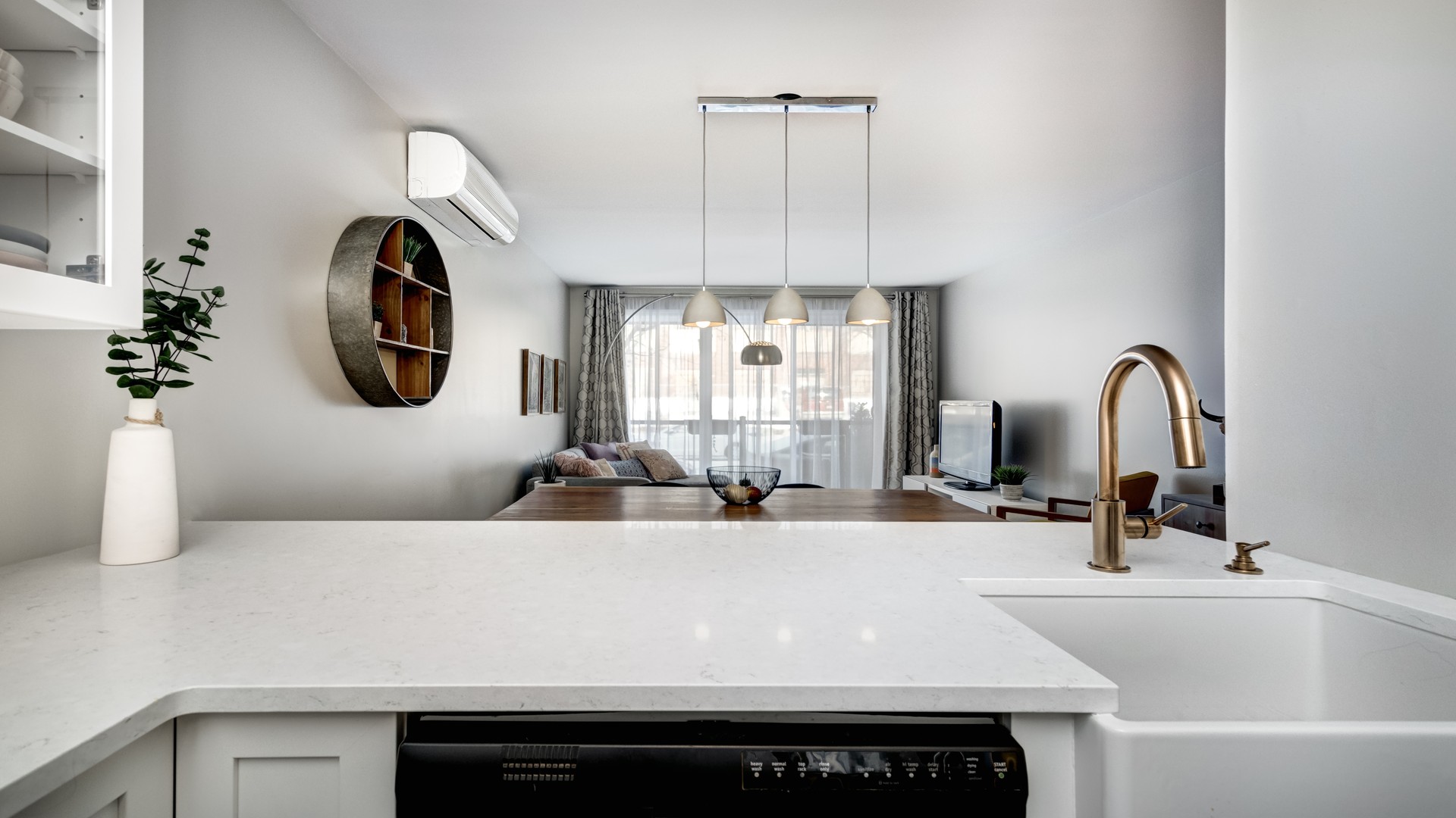 Finished white engineered quartz countertop with fine grey speckle in a bright residential kitchen